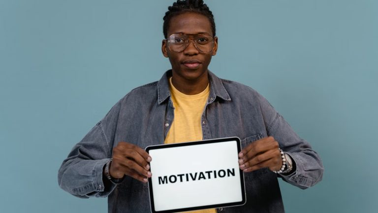 A young African American man holding a tablet displaying the word 'MOTIVATION' against a blue background.